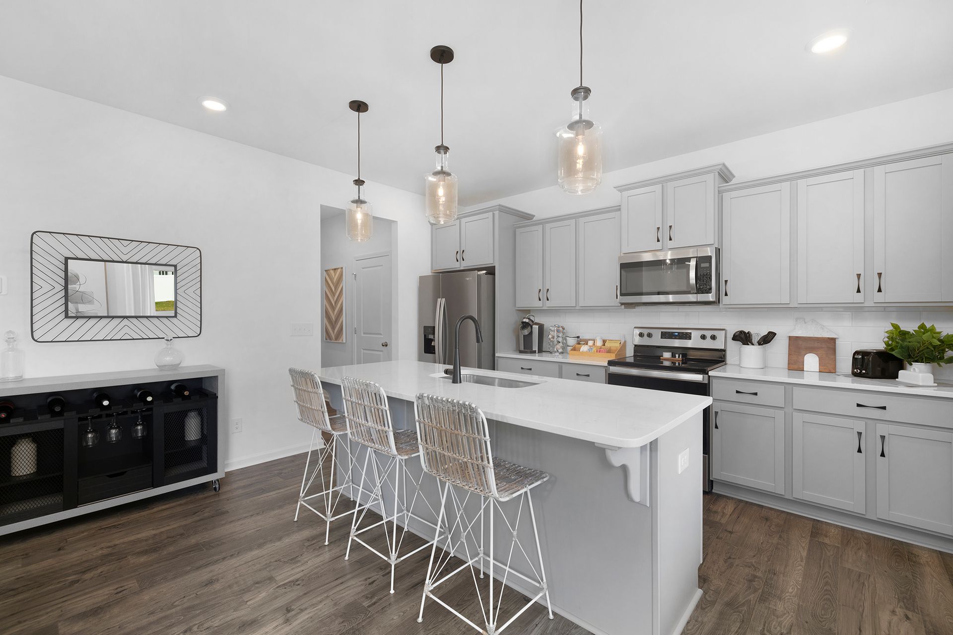 A kitchen with white cabinets , stainless steel appliances , and a large island.