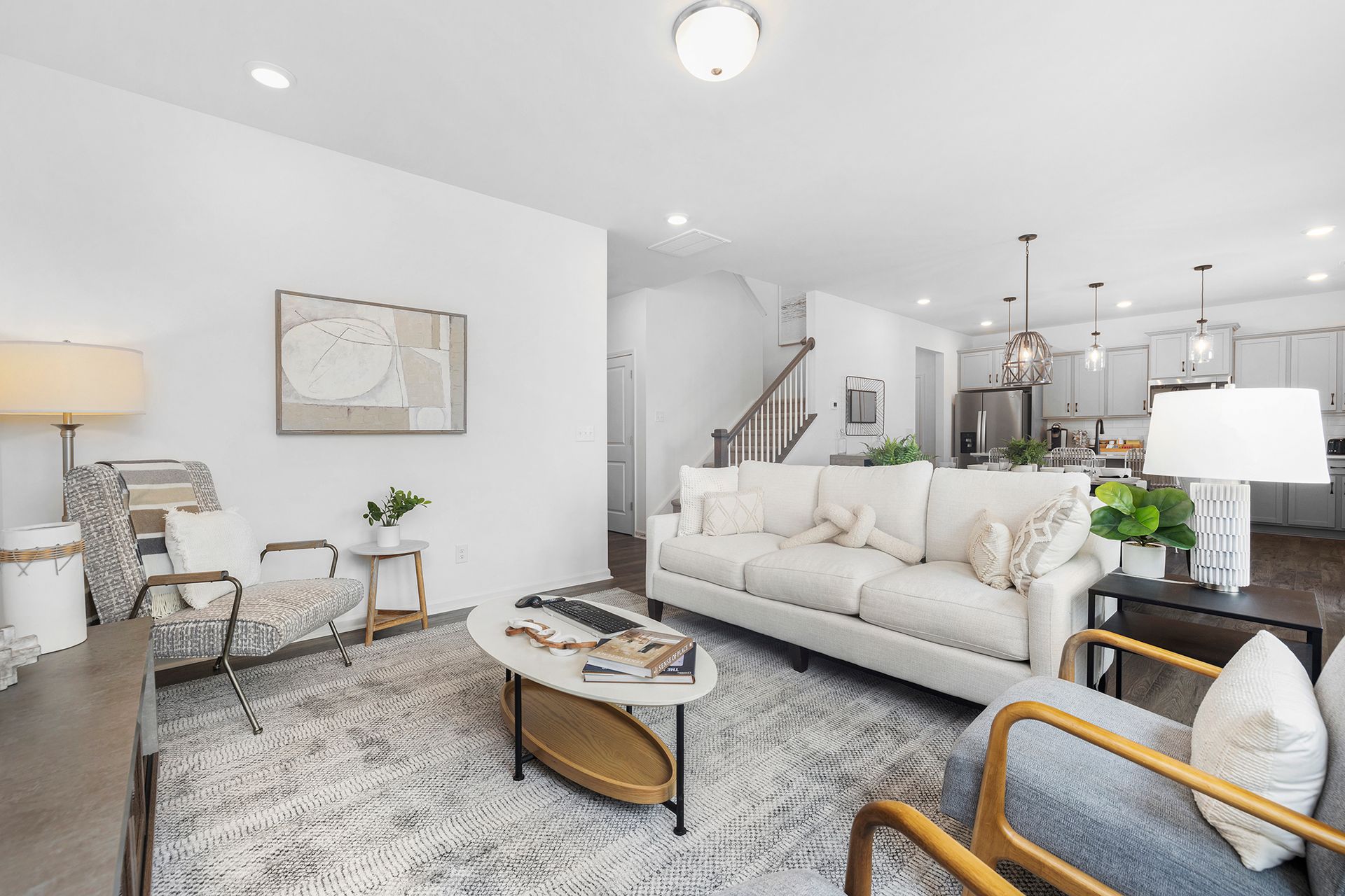 A living room with a couch , chairs , and a coffee table.