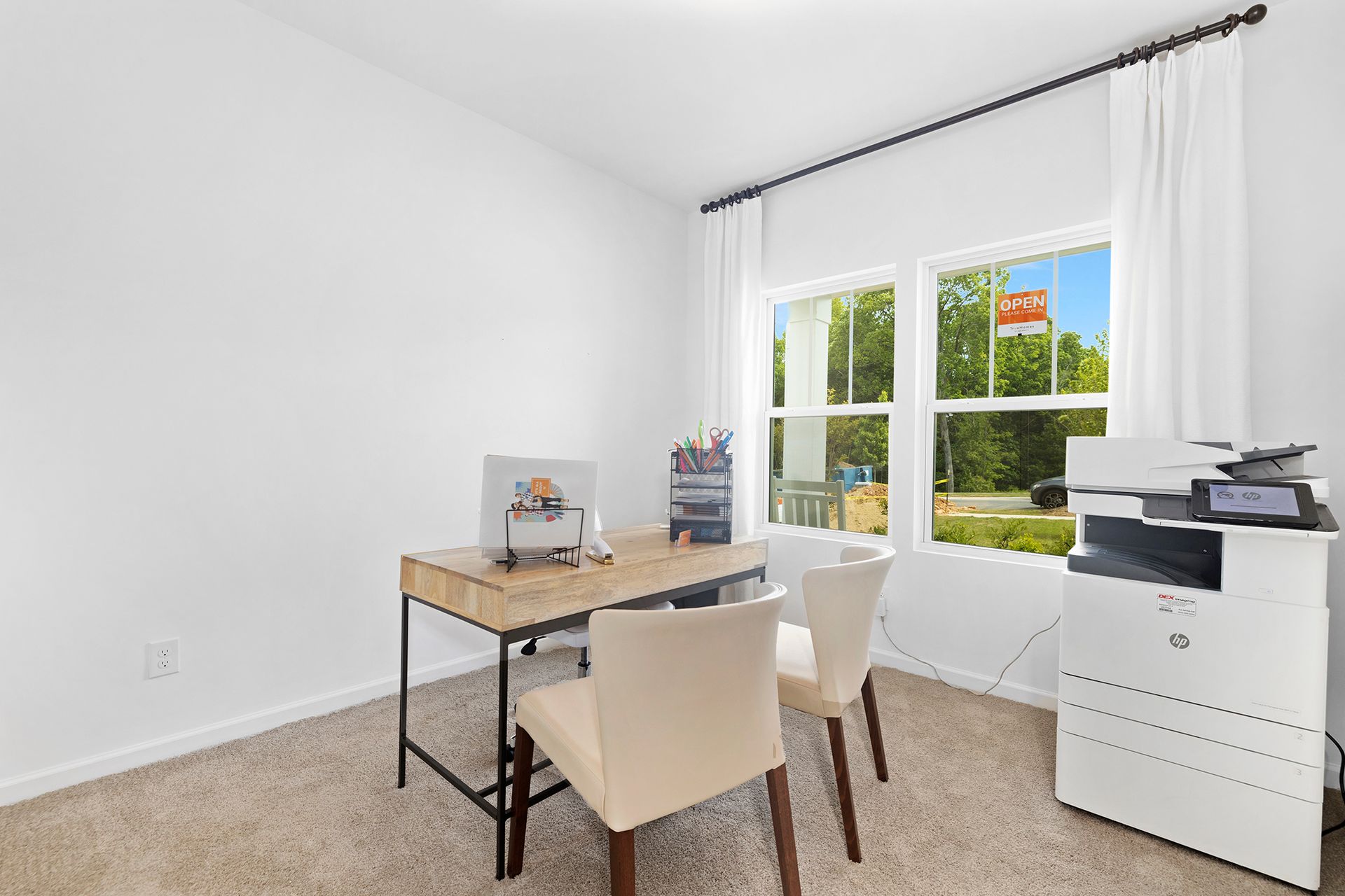 A home office with a desk , chairs , and a printer.