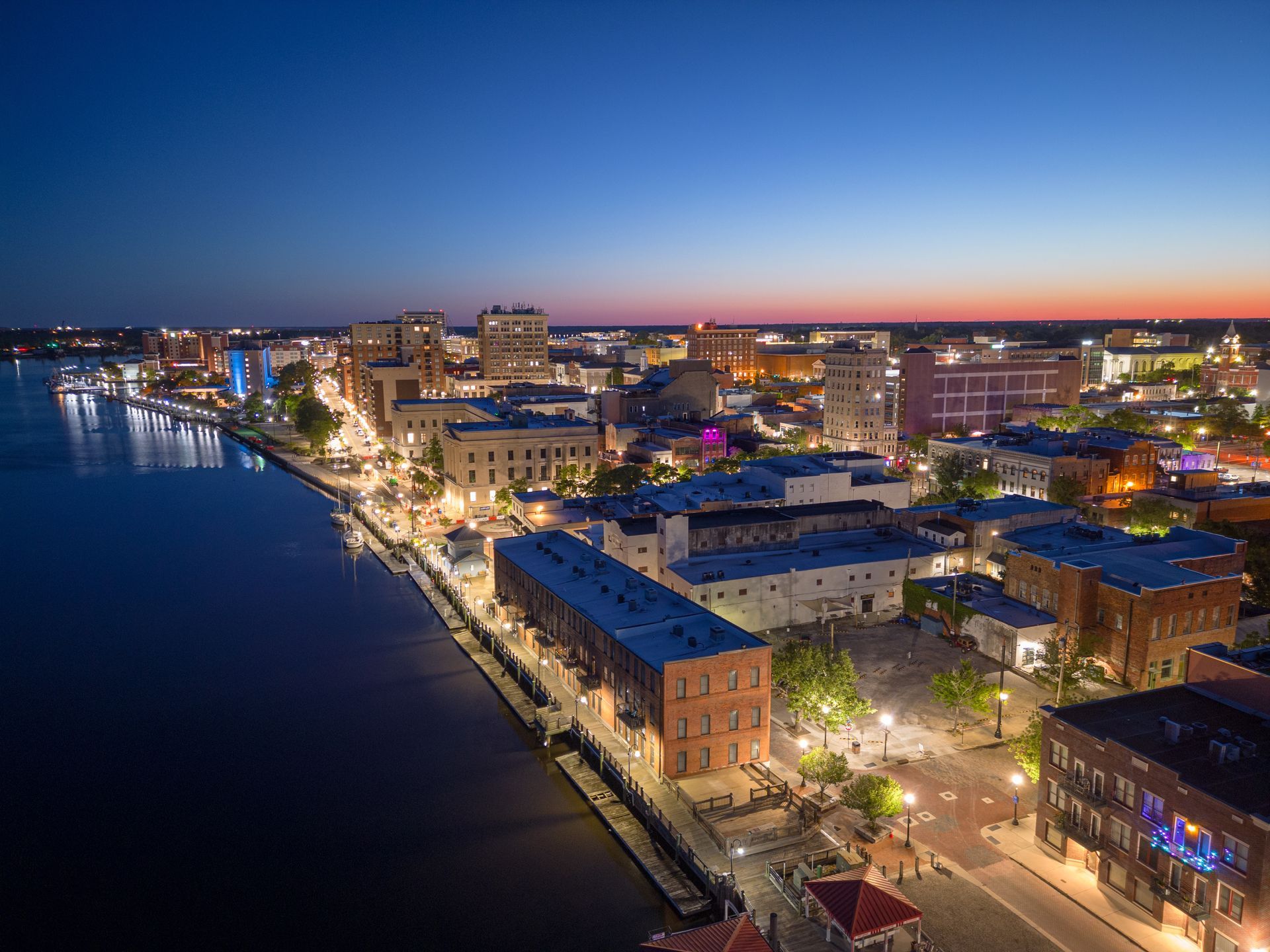 an aerial view of a Wilmington at night with buildings lit up