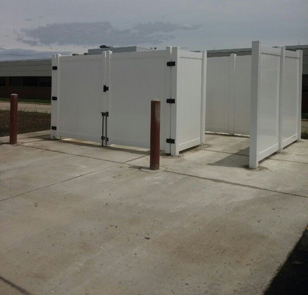 White fenced enclosure on a concrete pad