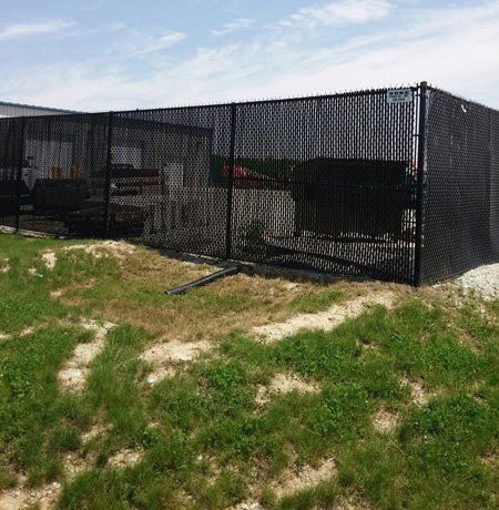 Black chain link fence surrounding a grassy area
