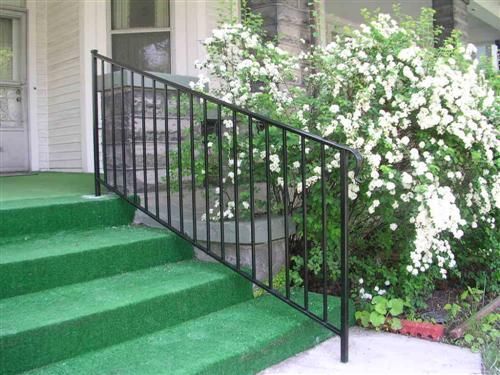 Black metal railing on green outdoor steps