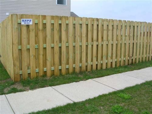 Wooden fence next to a sidewalk