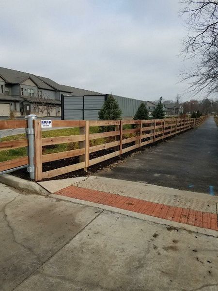 Wooden fence alongside a paved walkway