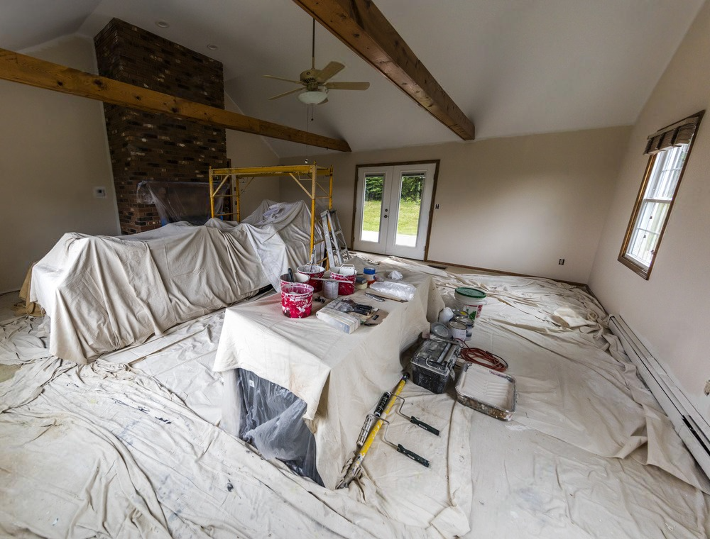 a room that is being painted with a table and tools on the floor .