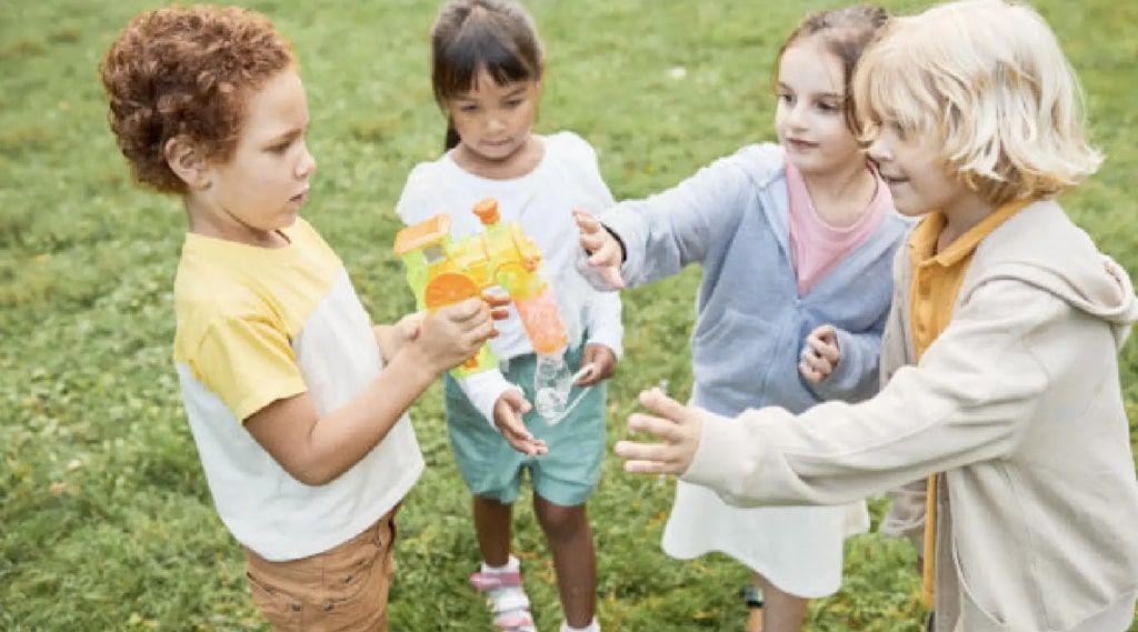 A group of children are standing in a circle in the grass.