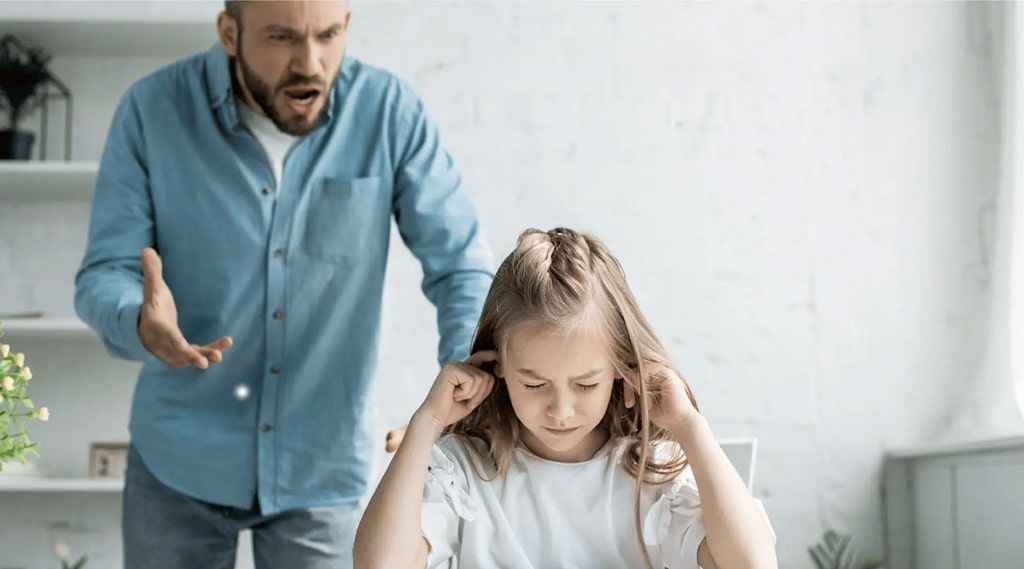 A man is yelling at a little girl who is covering her ears.