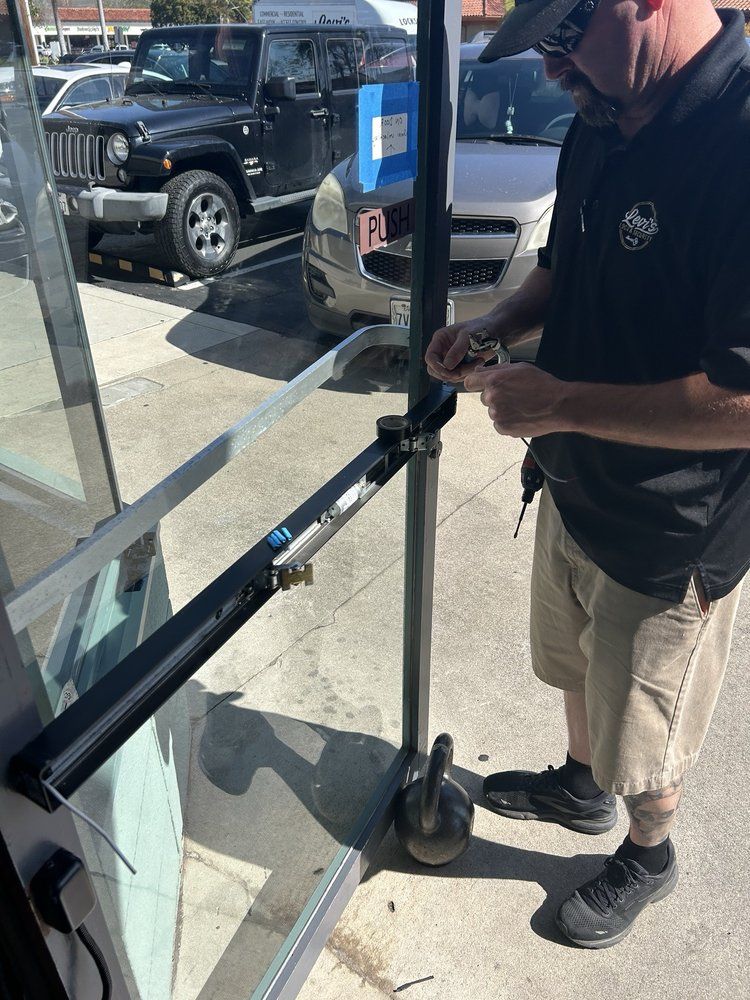 A man is standing in front of a glass door.