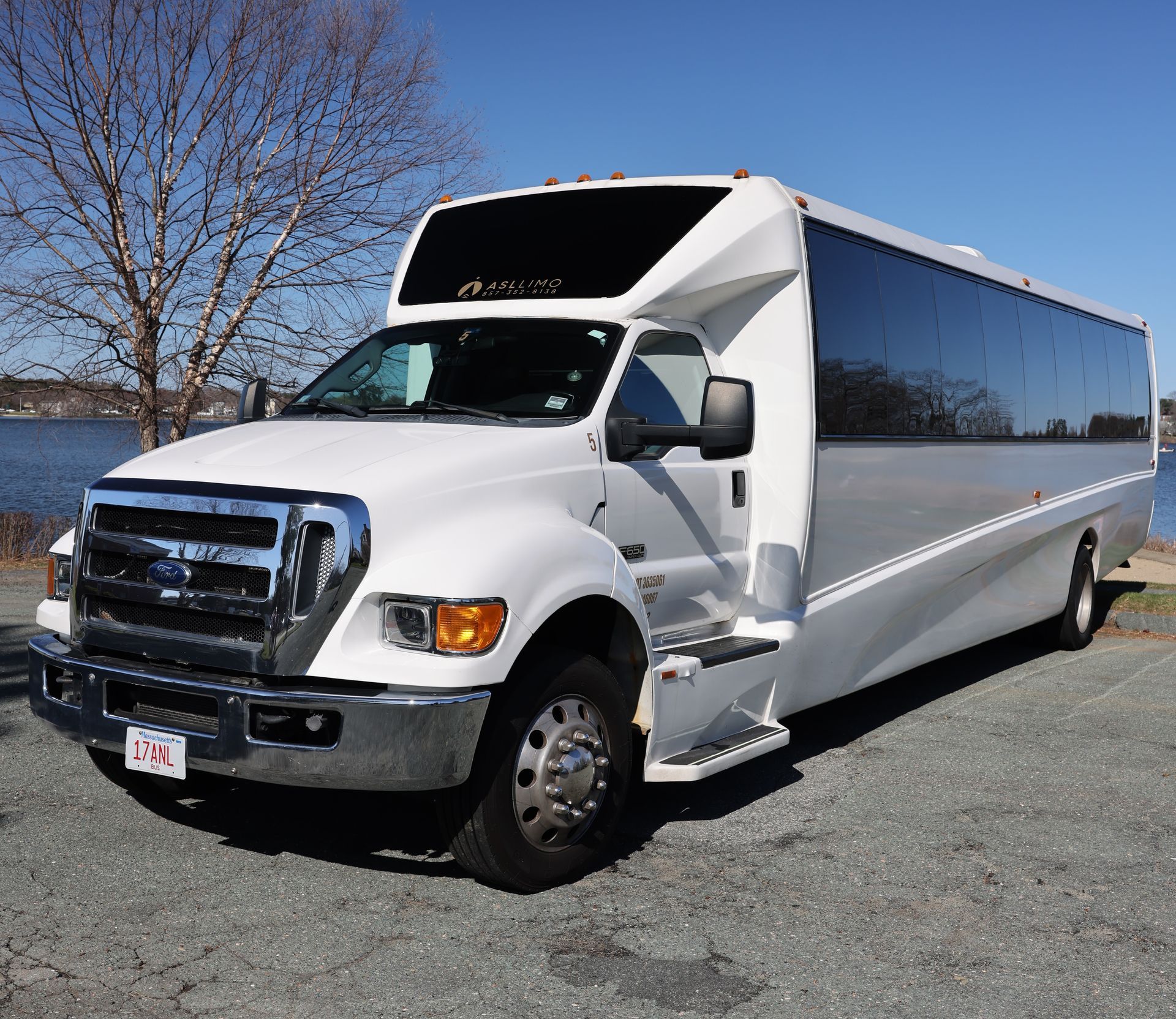 a black sprinter van is parked in a parking lot in front of a building .