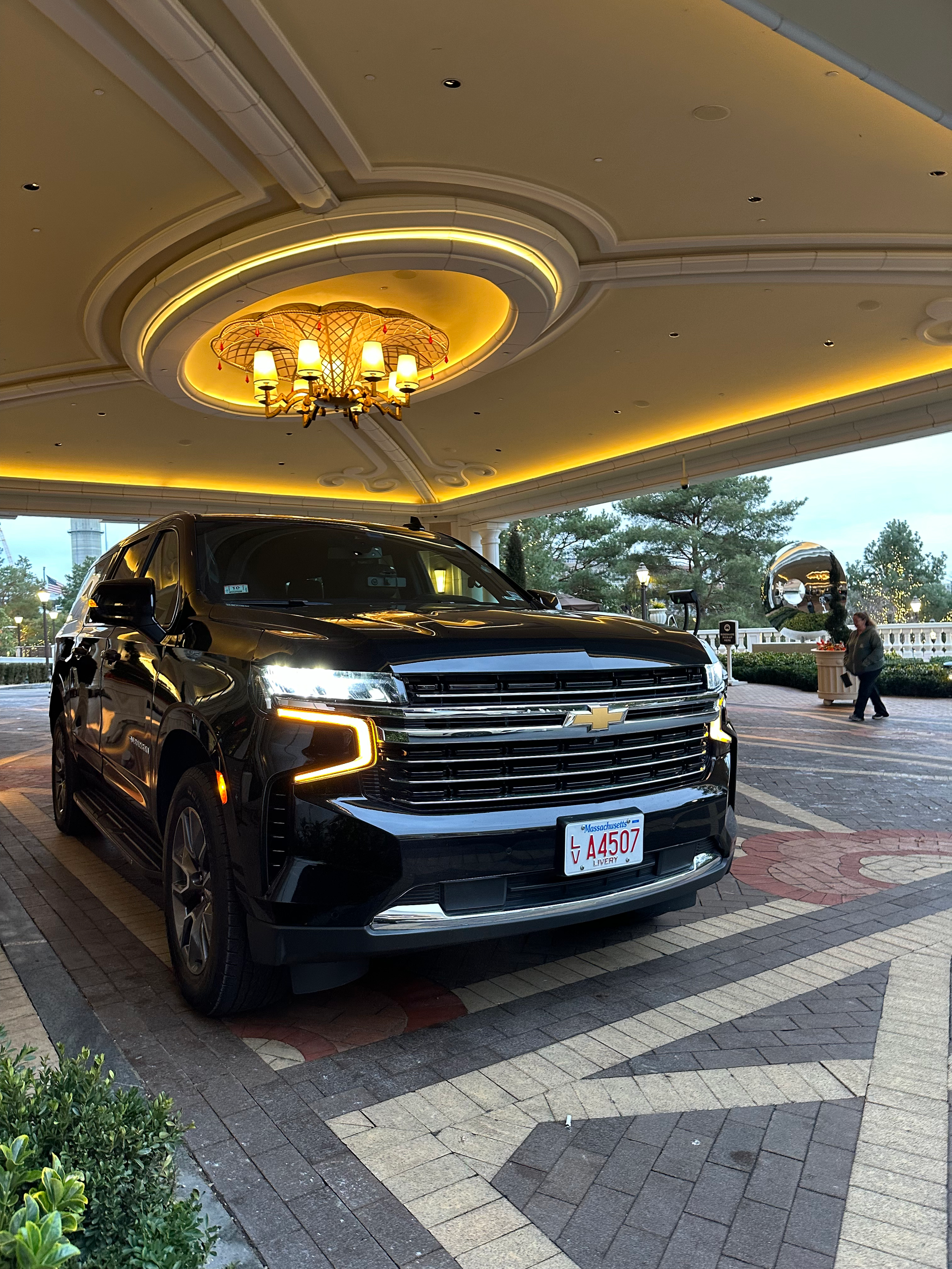 a black suv is parked in a parking lot under a ceiling light .