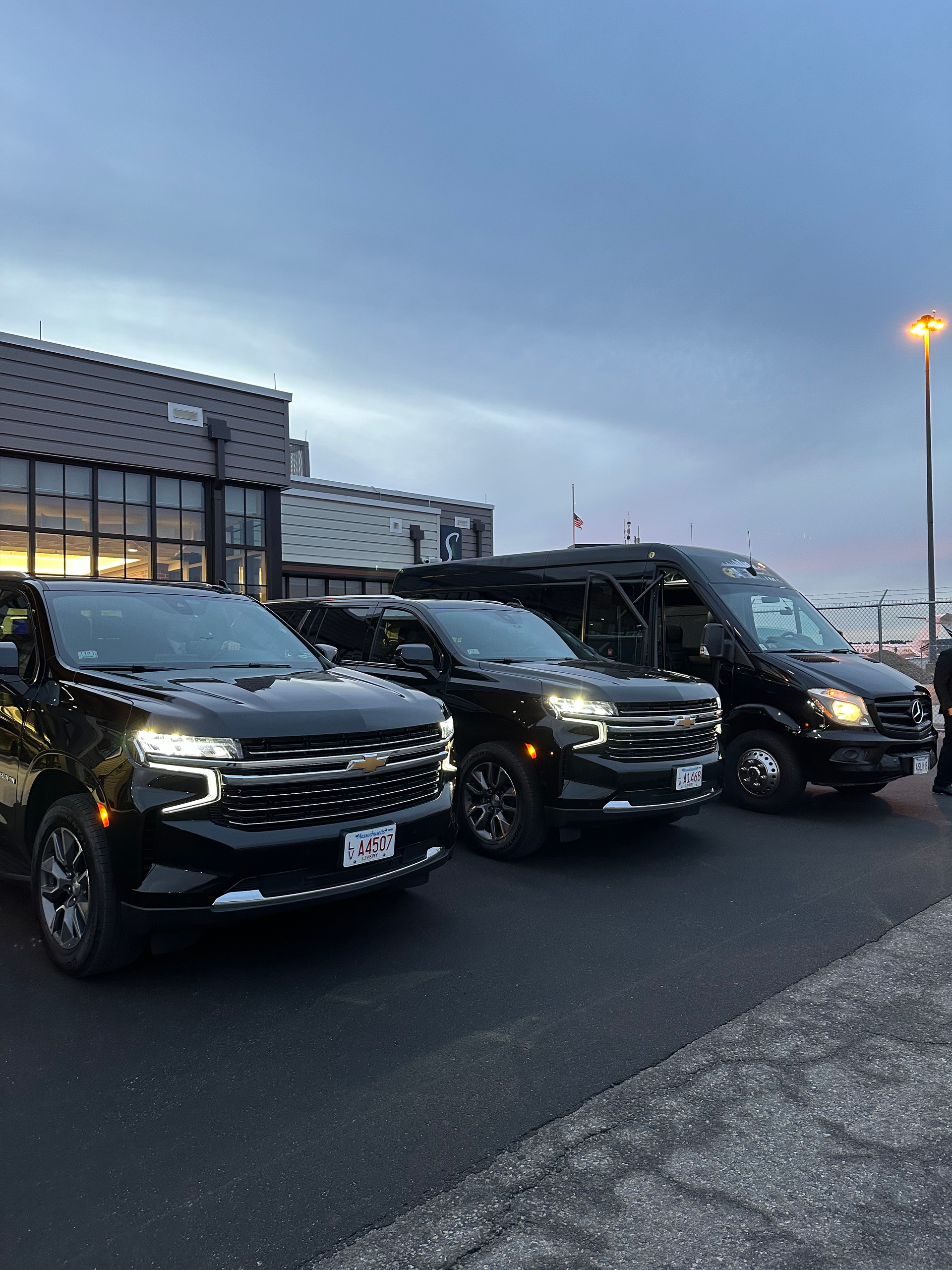 a row of black cars are parked in front of a building .