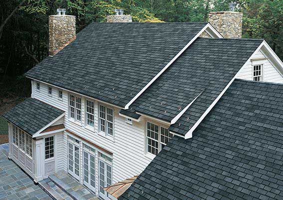 A Large White House With A Black Roof — Akron, OH — D&M Roofing LLC