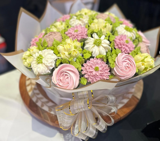 Cupcake bouquet in pastel colors, arranged in a floral design and tied with a ribbon.
