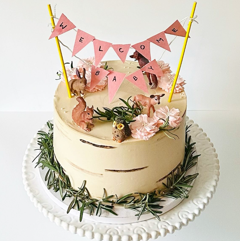 Cake decorated as a woodland scene with animals, flowers, and a
