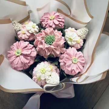 Bouquet of cupcakes decorated to look like flowers; shades of pink and white frosting.