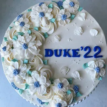 White cake decorated with white and blue flowers,
