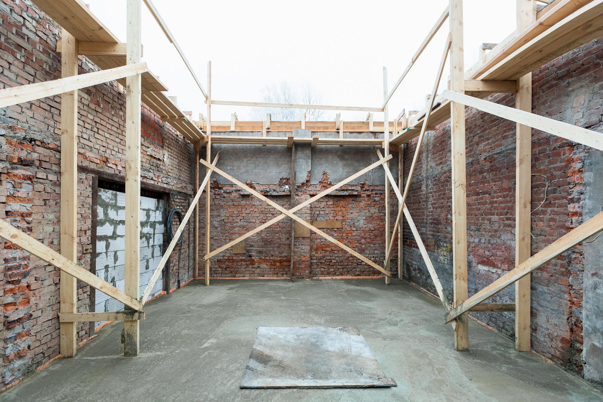 An empty room with brick walls and wooden beams.