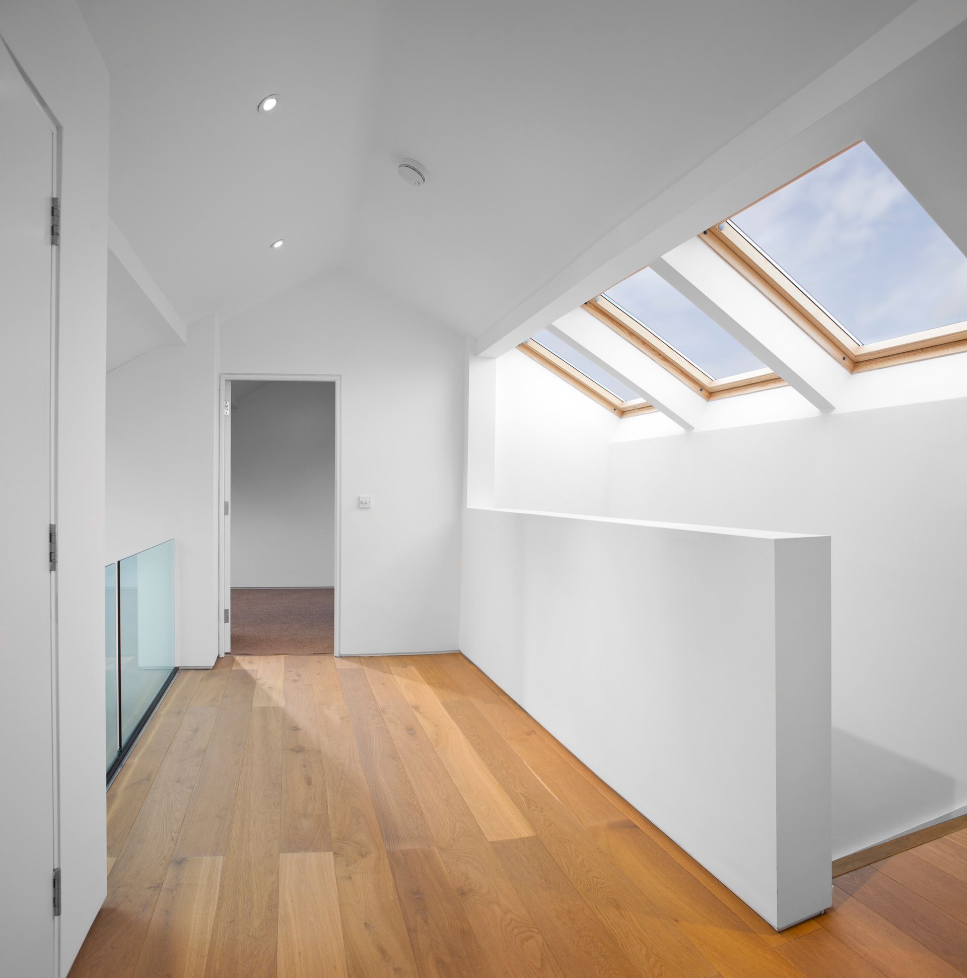 A hallway with a skylight in the ceiling.