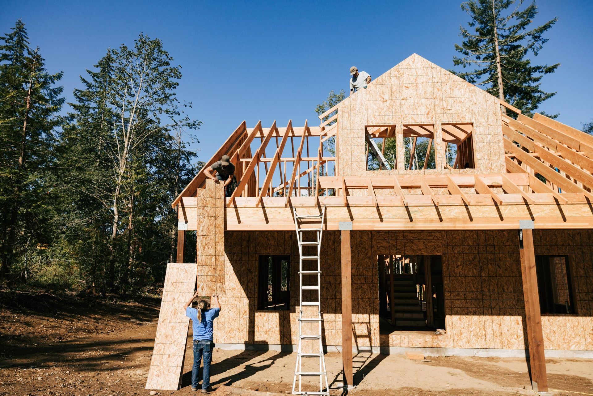 A man is standing in front of a house under construction.