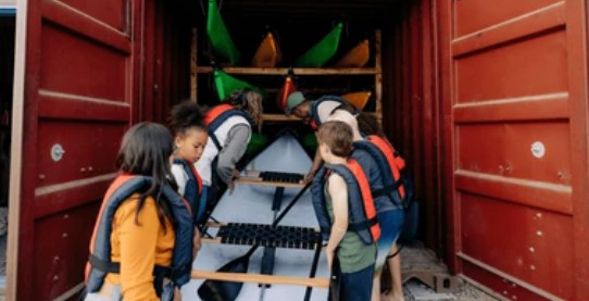 Kinds Loading Kayaks on a Metal Container