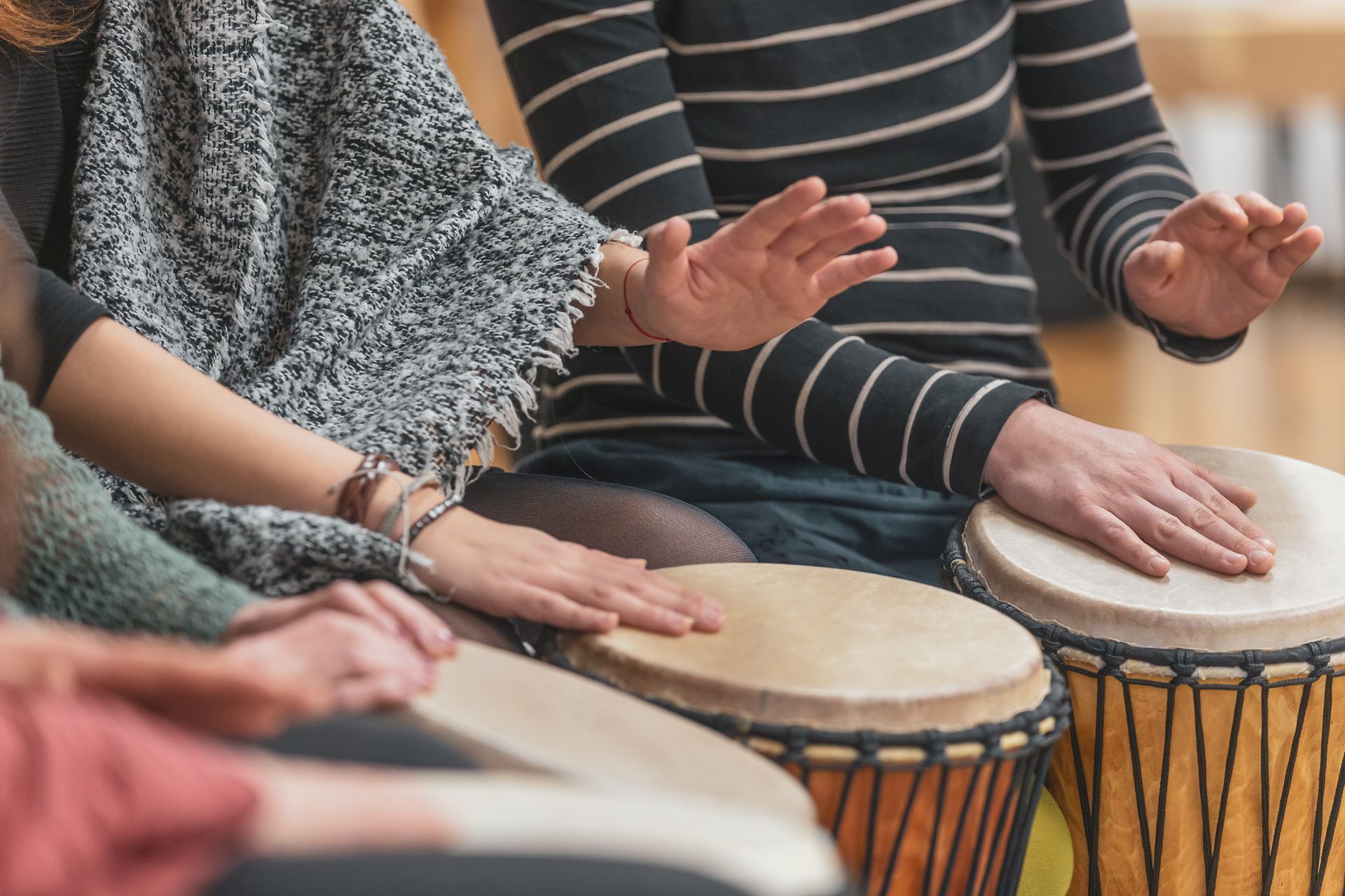 A group of people are sitting in a circle playing drums.