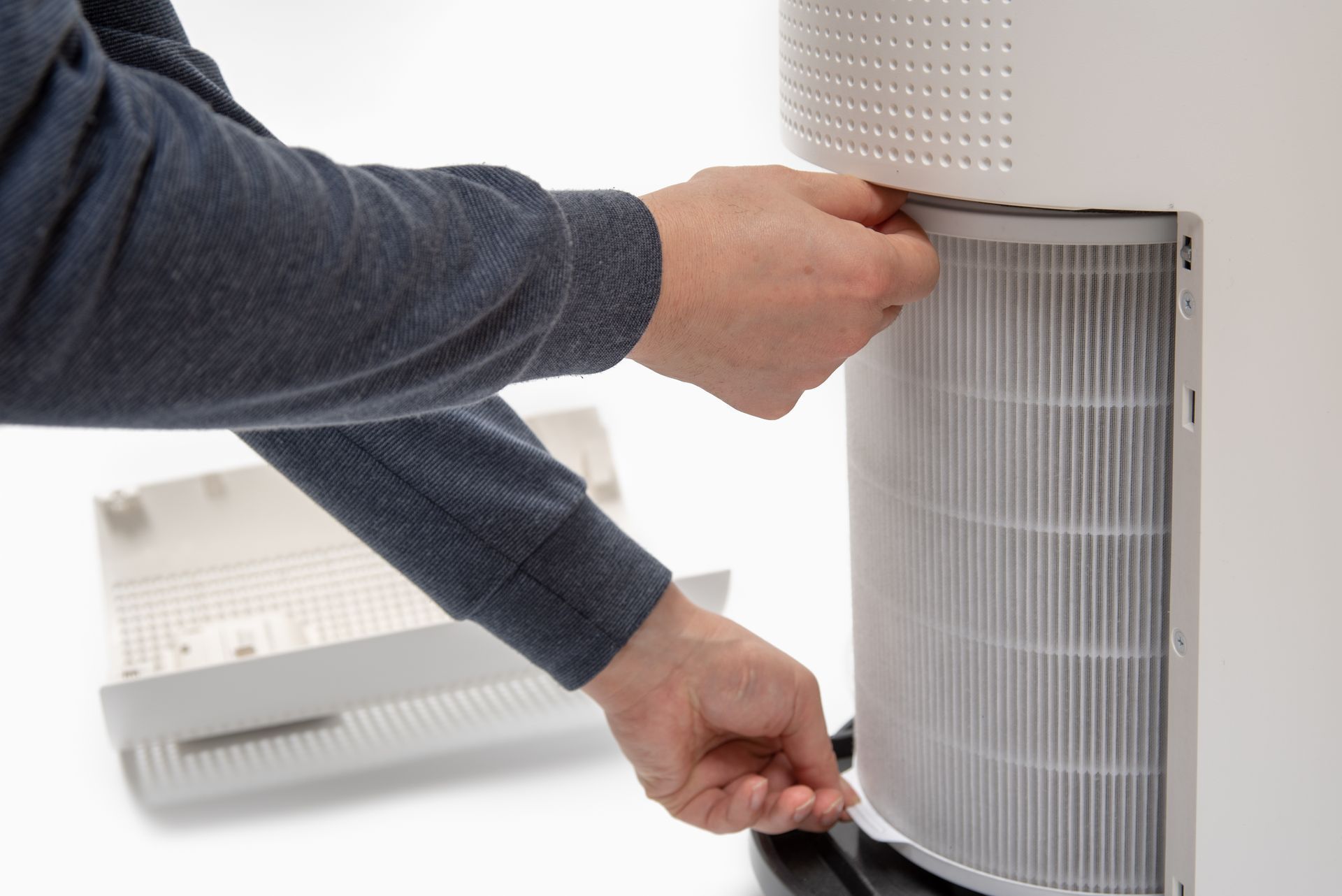 A person is changing a filter on an air purifier.