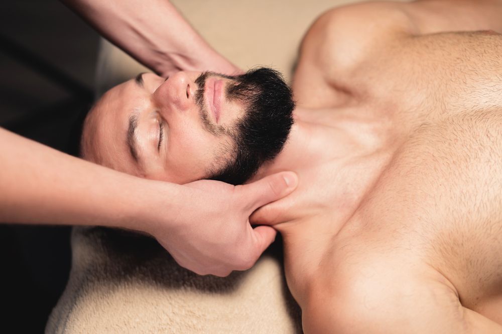 Person receiving a neck massage on a massage table.