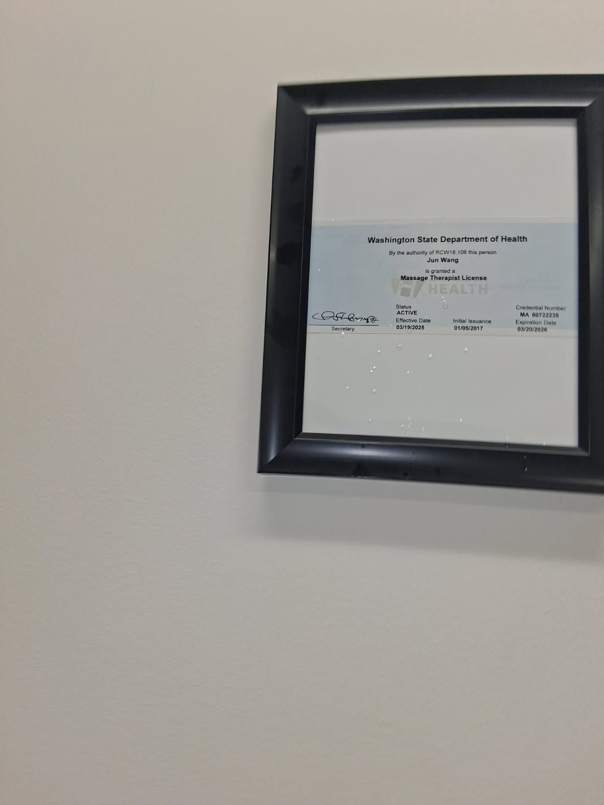 Framed document with blue and white sections on a white wall.