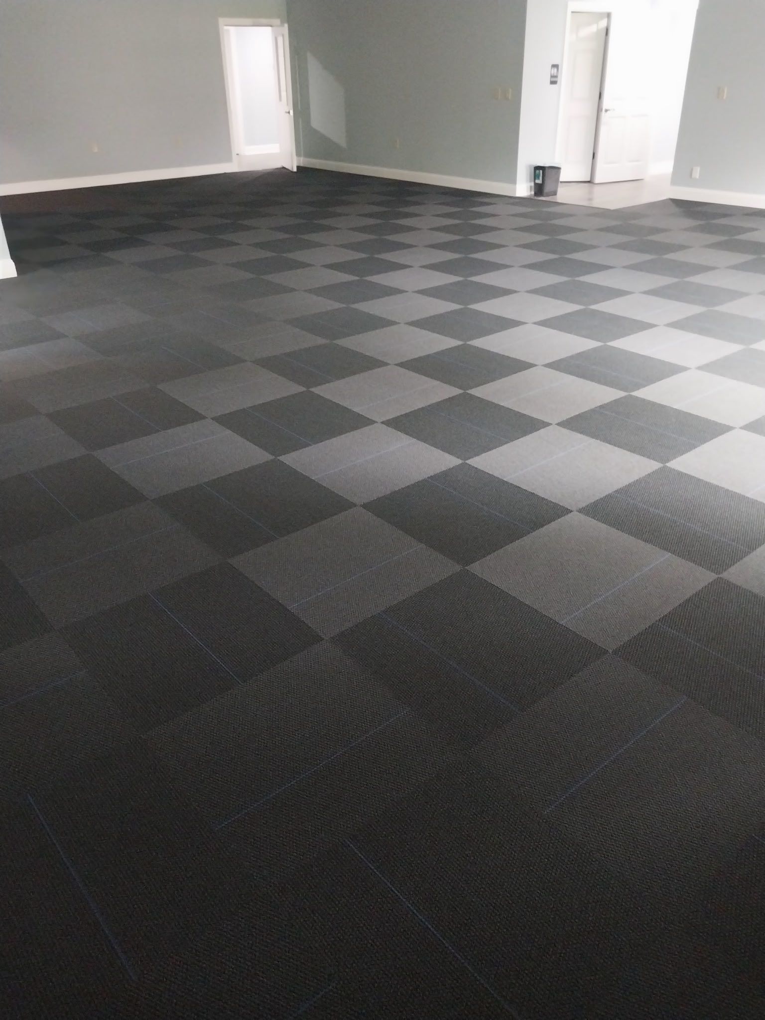 A large room with a checkered floor and a door.