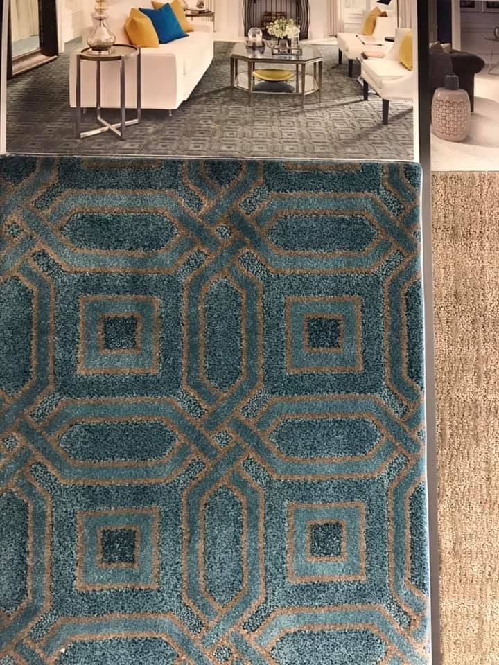 A living room with a blue rug and a picture of a rug.