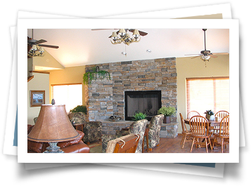 A living room with a fireplace and a ceiling fan