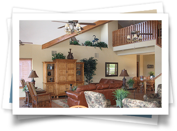 A living room with a couch and chairs and a ceiling fan