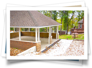 A picture of a pavilion with a roof and a brick wall.