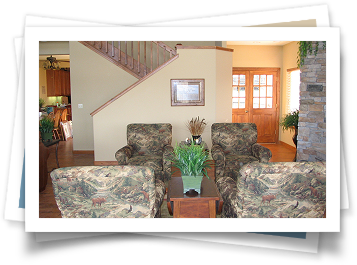 A picture of a living room with a staircase in the background