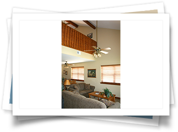 A picture of a living room with a ceiling fan