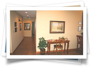 A picture of a hallway with a desk and chairs