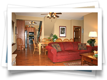 A living room with a red couch and a ceiling fan