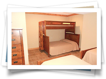 A bedroom with two bunk beds and a dresser