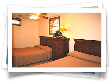 A bedroom with two beds and a ceiling fan