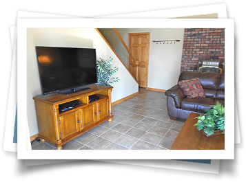 A living room with a couch , television , and fireplace.