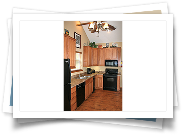 A picture of a kitchen with wooden cabinets and black appliances