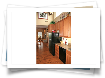 A picture of a kitchen with wooden cabinets and a black refrigerator