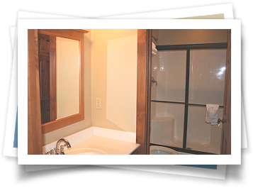 A bathroom with a sink , mirror and sliding glass shower door.