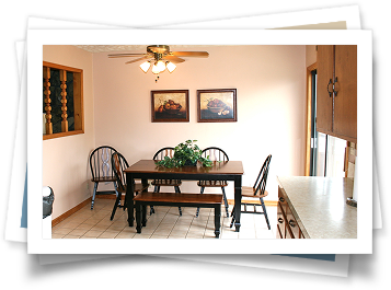 A dining room with a table and chairs and a ceiling fan