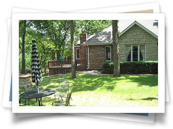 A picture of a house with a table and chairs in front of it