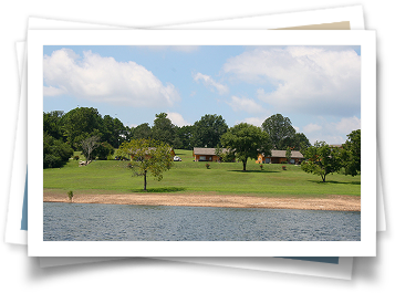 A picture of a lake with houses in the background