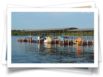 A bunch of boats are docked at a dock on a lake