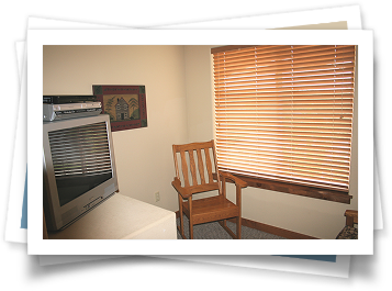 A picture of a room with a tv and a chair