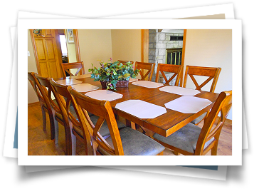 A dining room table with a vase of flowers on it